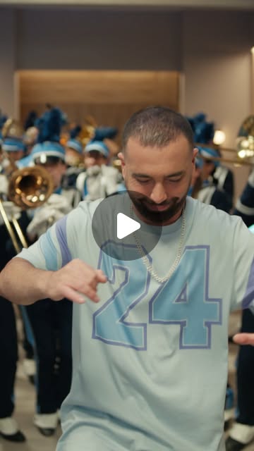 Omer Adam dancing in front of a marching band